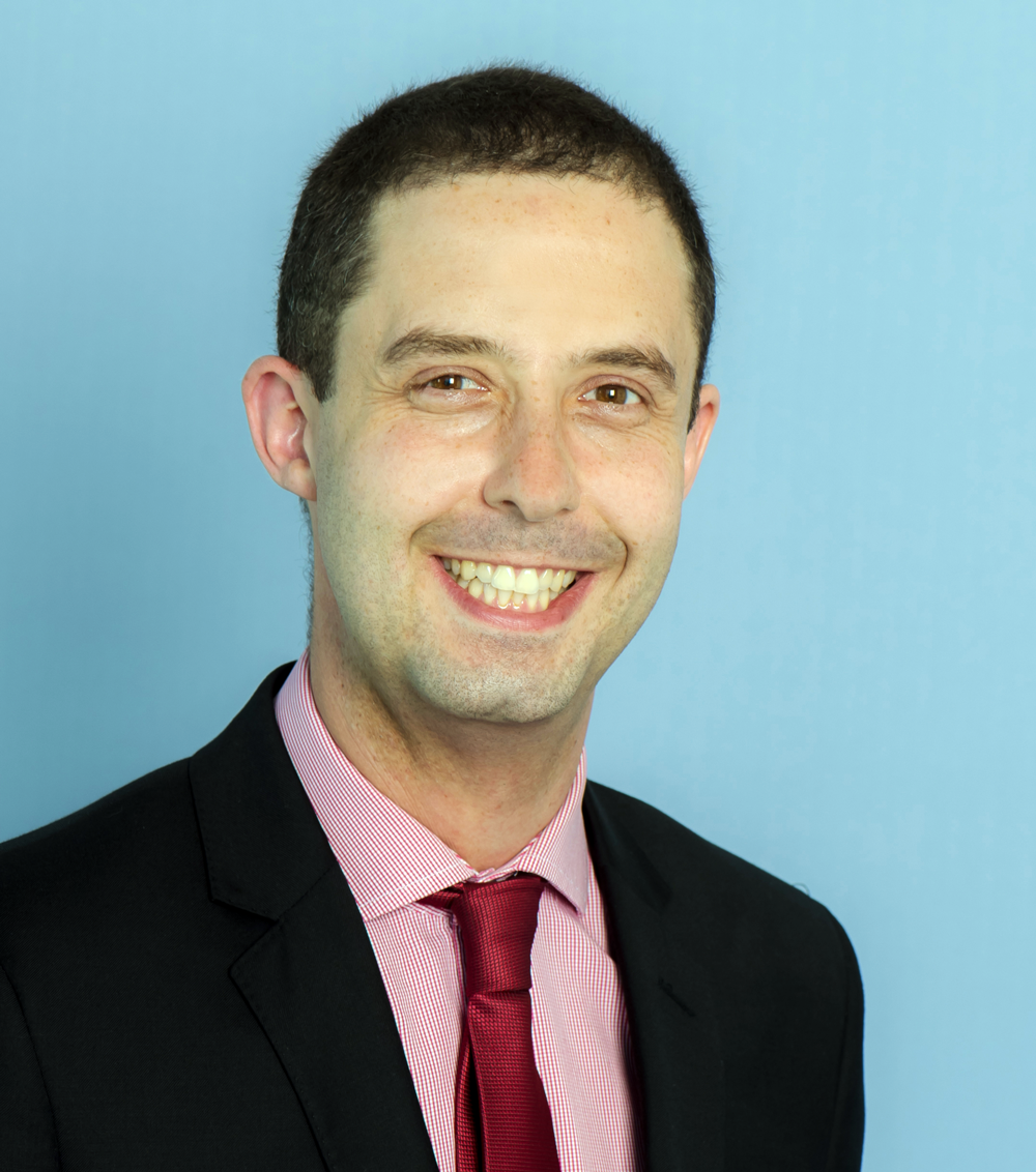 Man smiling at camera, wearing red tie