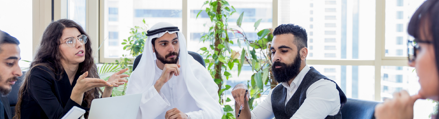 A group of 5 people sitting at a table having a discussion