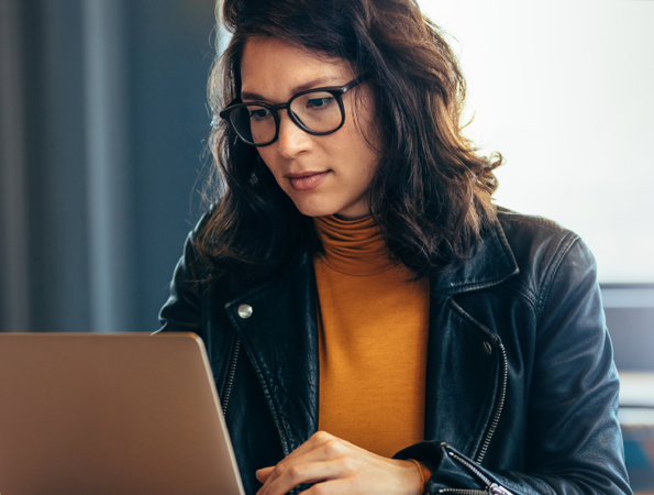 Asian woman with glasses staring at laptop
