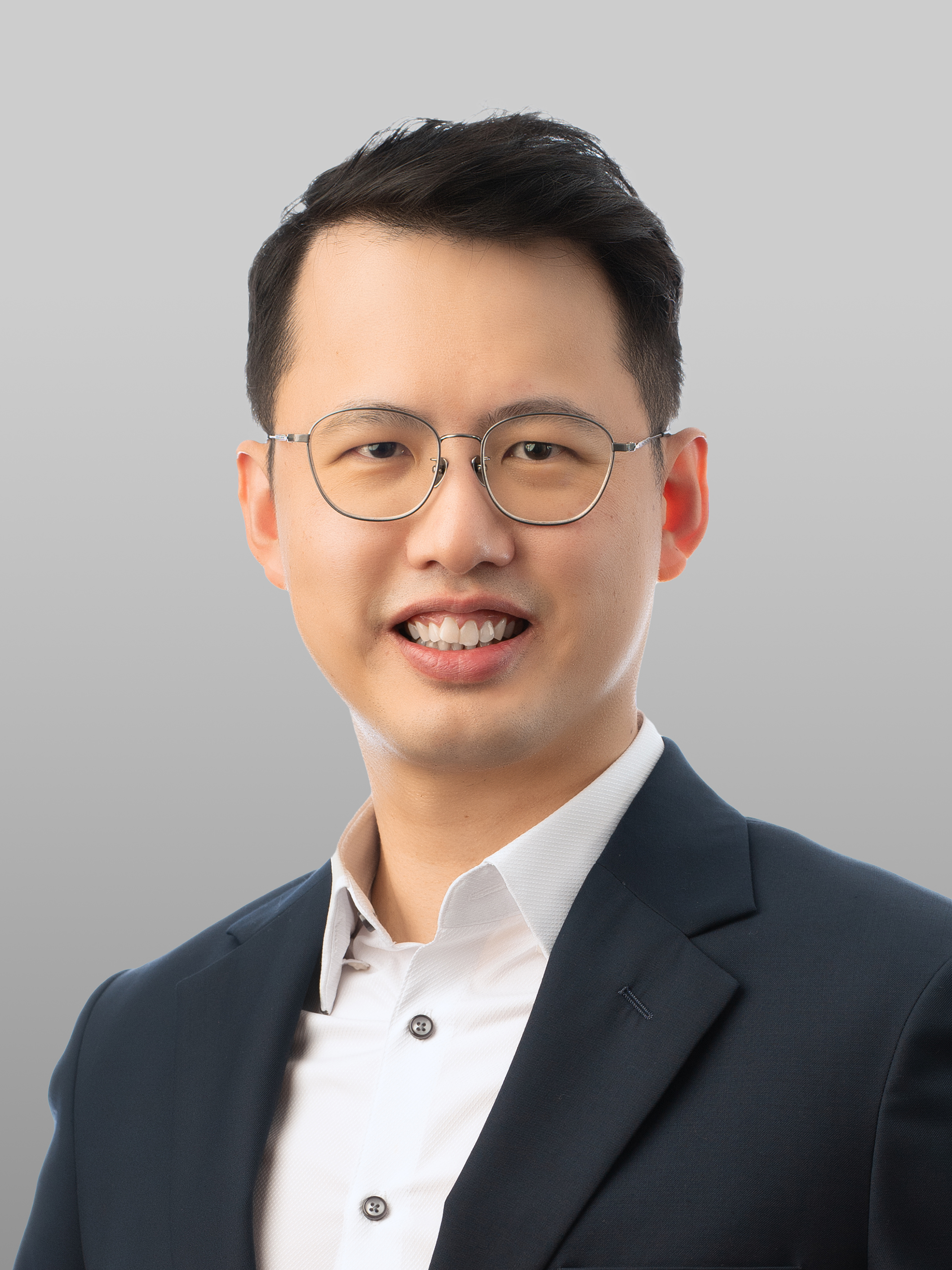 Man wearing glasses, smiling at camera