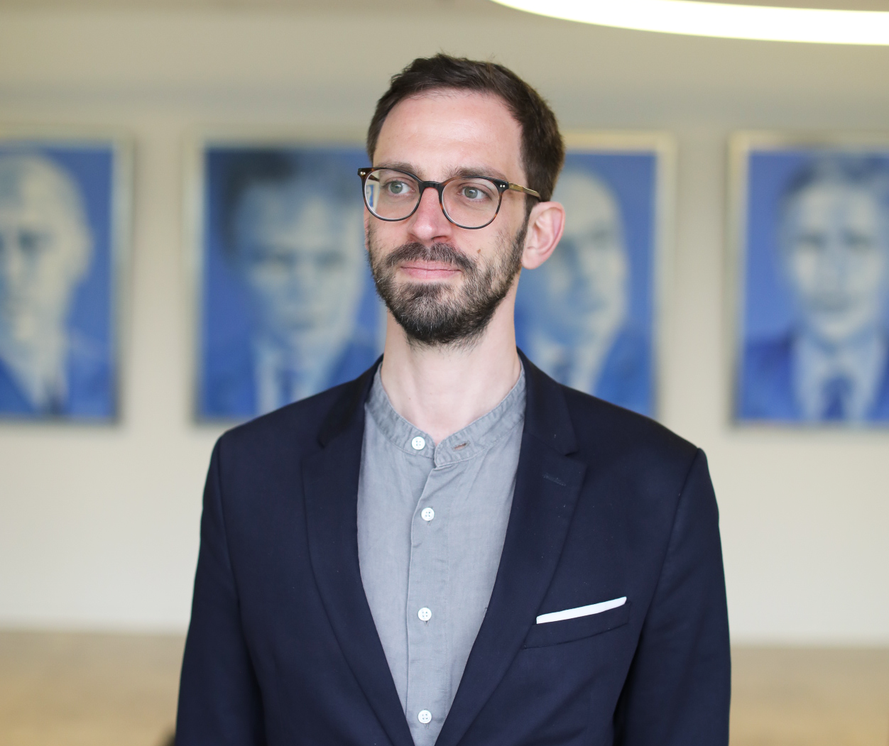 Man wearing glasses and suit, looking into distance
