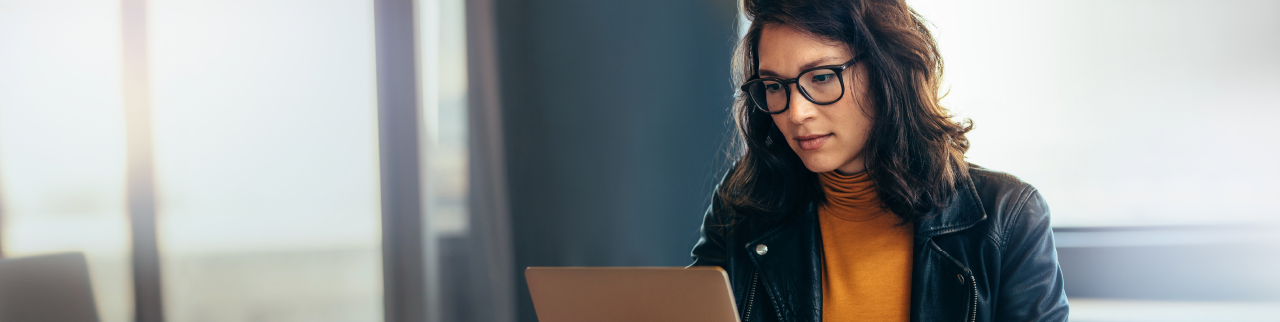 Asian women with glasses looking at laptop